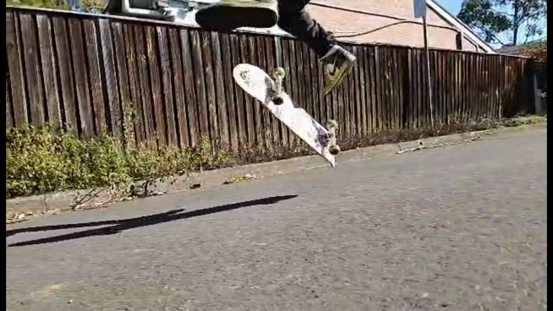 Skater performing a kickflip mid-air on an Australian street